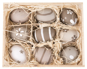 painted Christmas eggs in a wooden crate isolated