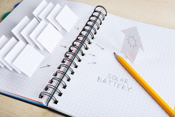 Applique paper with building and solar panels in notebook