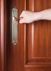 Hand gripping the handle of a door