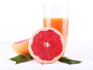 Grapefruit juice and fresh grapefruit on wooden table