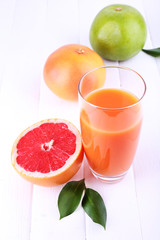 Grapefruit juice and fresh citrus on wooden table
