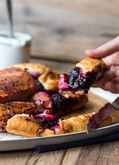 cake with blueberry jam on a wooden board, eat hand, baking