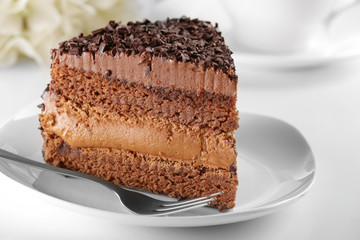 Delicious chocolate cake on plate on table on light background
