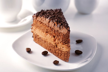 Delicious chocolate cake on plate on table on light background