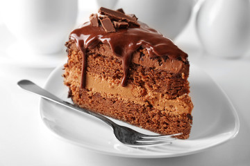 Delicious chocolate cake on plate on table on light background