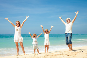 Happy family jumping on the beach on the day time