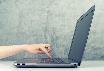 Woman pressing keypad on laptop computer