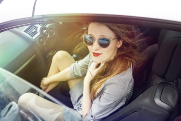 Fototapeta na wymiar Wonderful young woman sitting in a car