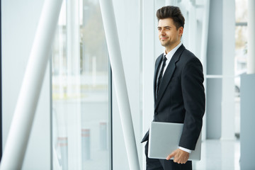 Businessman with Laptop Near the Window and Thinking About the F