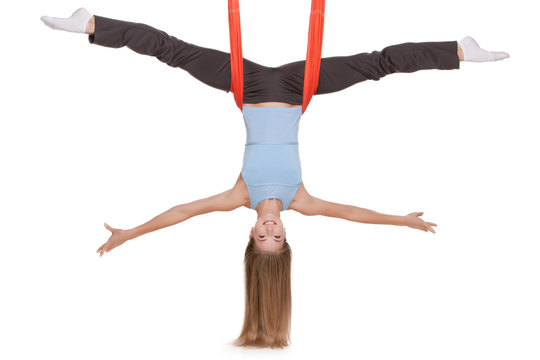 Young woman making aerial yoga exercises in stretching