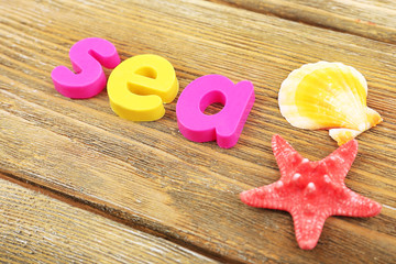 Sea word formed with colorful letters on wooden background