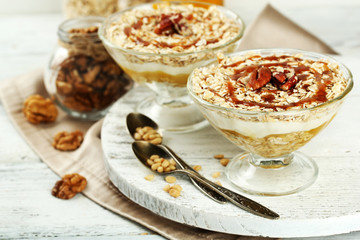 Tasty dessert with oat flakes and honey, on table