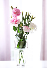 Beautiful flowers in vase with light from window