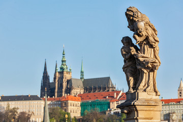 Fototapeta na wymiar Statue on Charles Brigde against St. Vitus Cathedral in Prague
