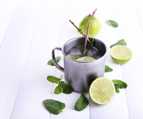 Lemonade in metal cup on wooden background