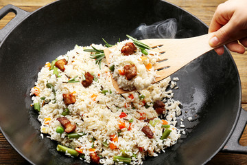 Tasty rice preparing in wok, close-up