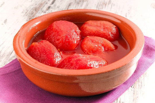 whole peeled tomatoes in a clay pot