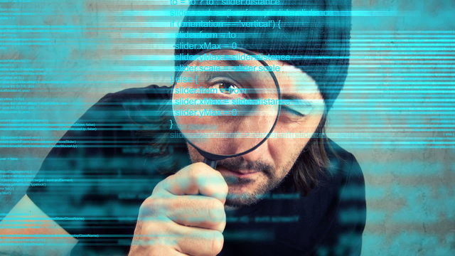 Man looking through magnifying glass and inspecting code