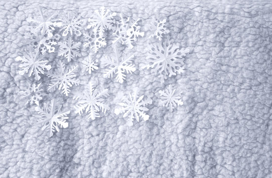 White paper snowflakes on bright wool background