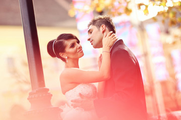 Obraz premium Bride and groom kissing and embracing in the city