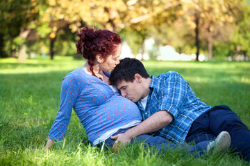 Pregnant couple relaxing in autumn park