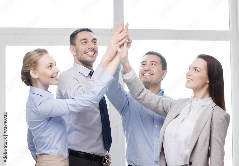 Wall mural happy business team giving high five in office