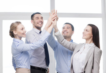 happy business team giving high five in office