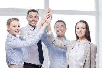 happy business team giving high five in office