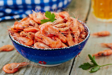 Prepared shrimp on blue plate on wooden background