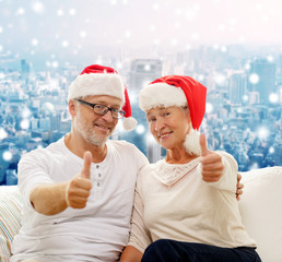 happy senior couple in santa helper hats