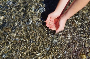 Beautiful woman hands on water
