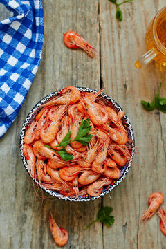Prepared shrimp on blue plate on wooden background