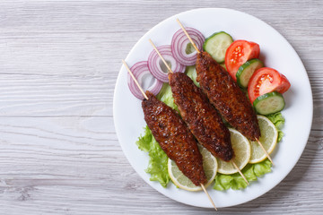 Kebab of minced meat on wooden skewers,  top view