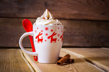 Hot chocolate with whipped cream in a mug with reindeer