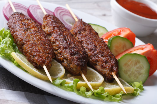 Three kebab of minced meat and fresh vegetables