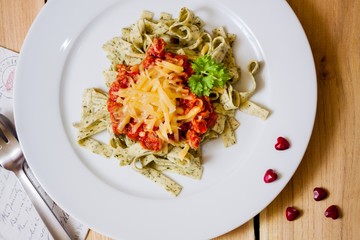 Green herb pasta with bolognese sauce with heart-shape pubbles