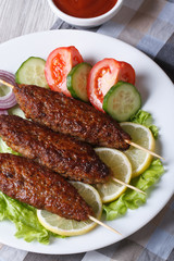 kebabs with vegetables and ketchup closeup. vertical top view