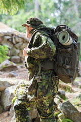 young soldier with backpack in forest