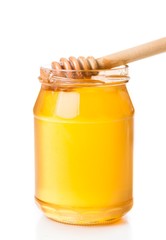 honey jar on white background with wooden honey dipper inside
