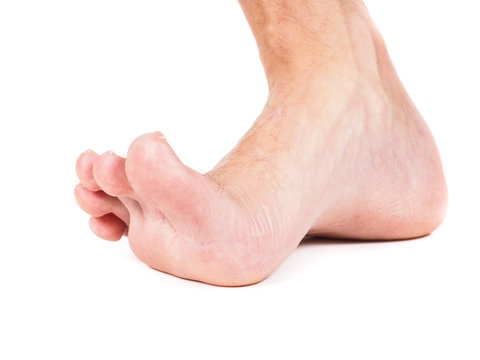 Male foot stepping barefoot isolated against white