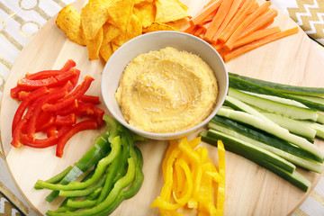 Hummus with vegetables on a wooden swivel table