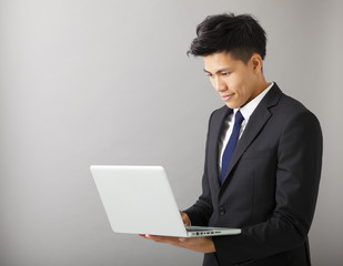 young smiling business man using laptop