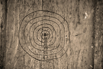 hand drawn dartboard on a wooden board in sepia tone