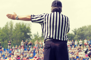 American football referee and de-focused players.