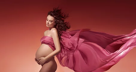 Poster Im Rahmen Amazing pregnant woman touching her belly © konradbak