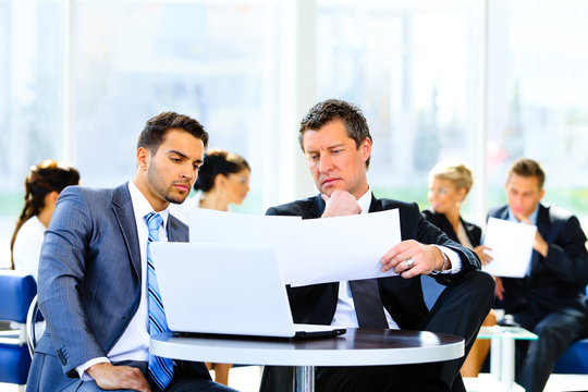 Two Confident Business People In Formalwear Discussing