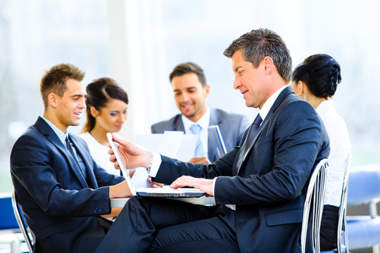 Happy businessman using laptop in business building, - Powered by Adobe