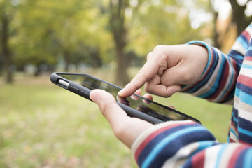 Boy to operate the mobile phone in the park