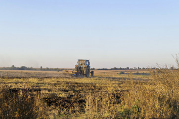 Fototapeta premium Tractor cultivating wheat stubble field with crop residue