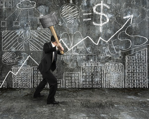 Businessman hold sledgehammer to crack hand-drawn doodles concre
